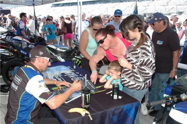 Three-time Superbike Champion Josh Hayes signs posters for fans.